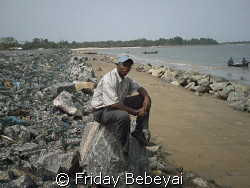I am at the sea bank of the costal rock looking my countr... by Friday Bebeyai 